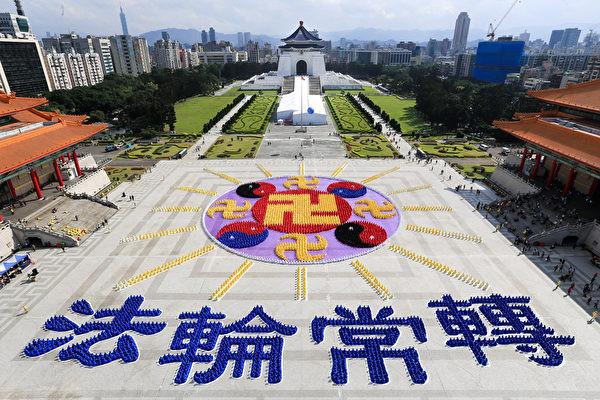 Environ 7 000 pratiquants de Falun Gong ont participé à des activités de formation de caractères et d'images sur la place de la Démocratie devant la salle commémorative Chiang Kai-shek. Les caractères signifient que la roue de la Loi tourne constamment, et l'image est l'emblème du Falun. (Image : E T)