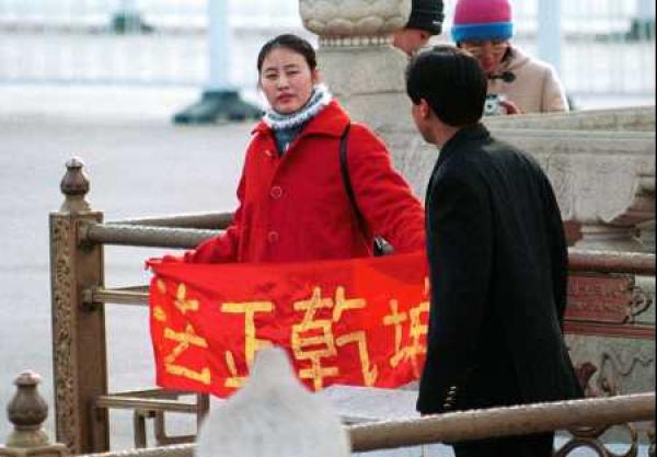 Une pratiquante de Falun Gong brandit une bannière disant «Vérité, Compassion, Tolérance» en Chine. (Image: Minghui.org)