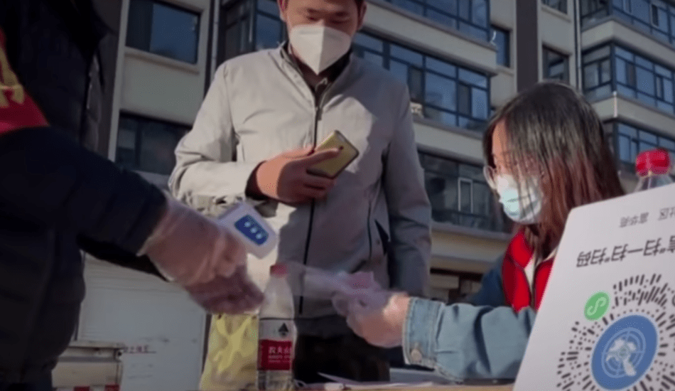Une femme à un point de contrôle de l’épidémie dans le district de Daowai à Harbin en avril 2020. (Image : Capture d’écran / NTDTV)