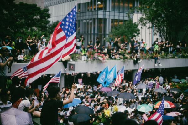 Des manifestants pro-démocratie brandissent des drapeaux américains lors d’une marche vers le consulat américain de Hong Kong pour demander l’aide de l’administration Trump, afin de mettre fin à une confrontation de trois mois avec le gouvernement pro-Pékin de Hong Kong, le 8 septembre 2019. (Image : Joseph Chan / Unsplash)